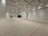 Semiarraum Weltkulturhaus leerer Raum mit Holzdielen und einem schwarzen Klavier im Hintergrund