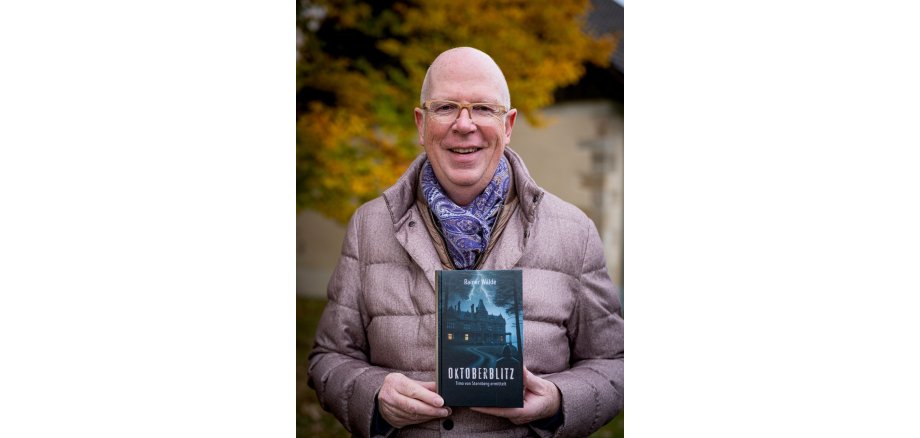 Portrait von Painer Wälde mit seinem Buch vor sich