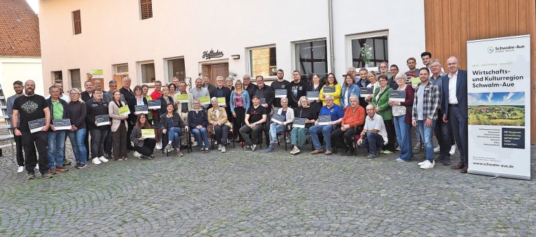 Gruppenfoto mit allen Projektträgern vor dem Eingang zum Hofladen; ganz rechts ein Aufsteller mit der Aufschrift: Wirtschafts- und Kulturregion Schwalm-Aue